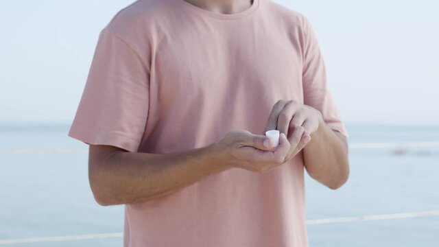 Young Caucasian Male using Hydroalcoholic Gel Washing his Hands to Prevent Diseases