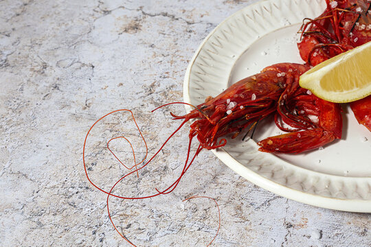 Scarlet shrimps with aromatic lemon pieces on plate