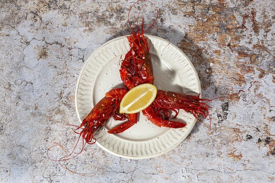Scarlet shrimps with aromatic lemon pieces on plate