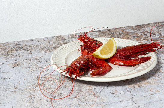 Scarlet shrimps with aromatic lemon pieces on plate