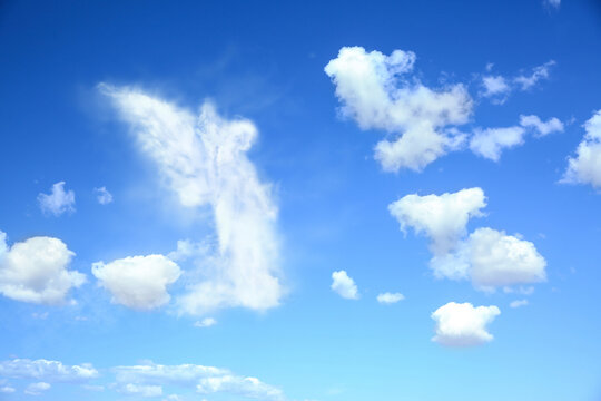 Silhouette of angel made of clouds in blue sky