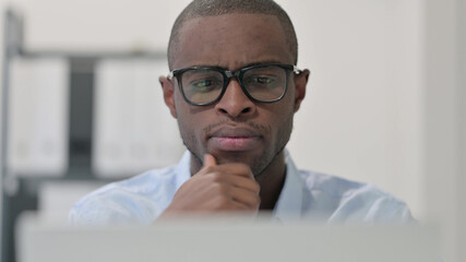 Close Up of Pensive African Man Using Laptop, Thinking