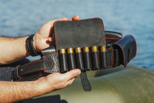 Handmade genuine leather patronage in the hands of a hunter. Accessories for hunting and outdoor recreation. DIY saddlery products.