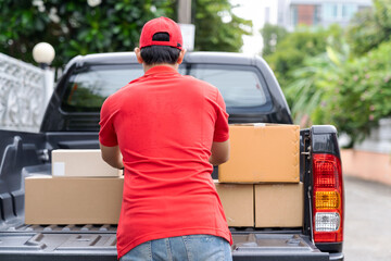 Asian delivery man wearing red uniform and red hat moving and transfer parcel boxes. Concept of...