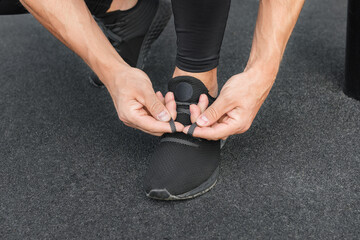 Young male jogger athlete training and doing workout outdoors in city.