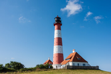 Fototapeta na wymiar Der Westerhefer Leuchtturm auf einer Warft im Wattenmeer, der Nordsee