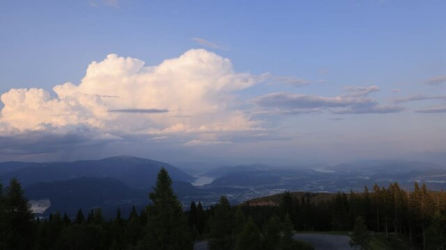 Zeitraffer von Quellwolken &uuml;ber Stadt Villach bei tief stehender Sonne