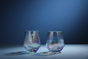 Empty glass Cup for alcoholic beverages isolated on Blue background with light streaks