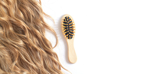 Long blond wavy hair and brush isolated on white
