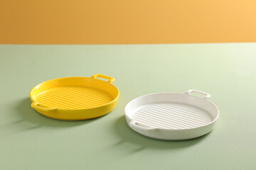 Multi-colored plates on table. Empty plate used to store meat and eggs