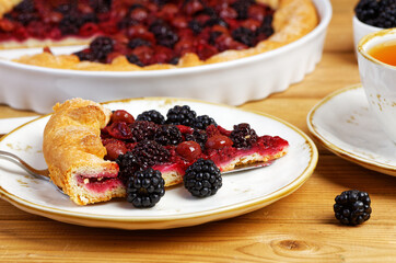 Closeup piece of homemade open pie gallet with raspberries, blackberry and grapes. Shallow focus.