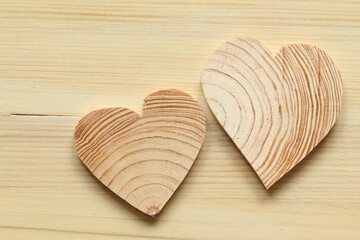 Wooden hearts on a light background. Wooden hearts carved from wood. Painted wood background. 
