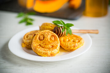 sweet lush pumpkin pancakes with honey in a plate