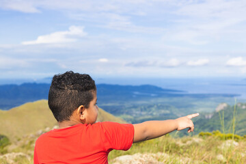 Fototapeta na wymiar latin boy pointing fingers at the mountain