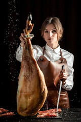 Professional cutter carving slices from a whole bone-in serrano ham, Spanish jamon iberico, Jamon...