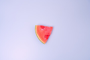 lonely piece of red watermelon without seeds on blue table