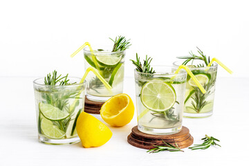 Fresh cold beverage with summer herbs and lemon in glasses