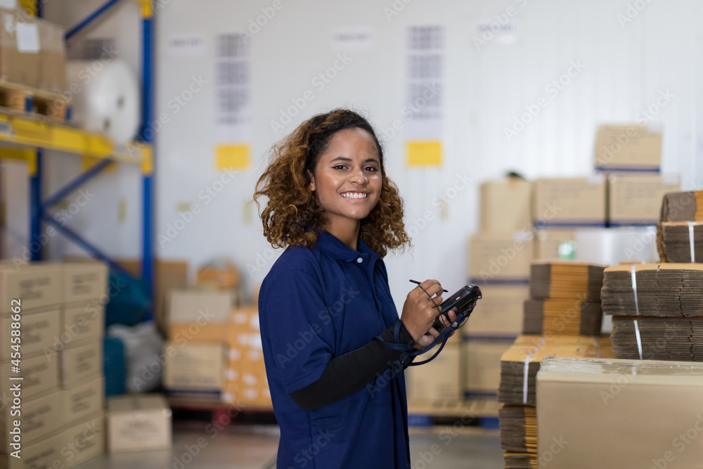 Wall mural Portrait of warehouse female worker in the warehouse storage with happy and smile. Inspection quality control