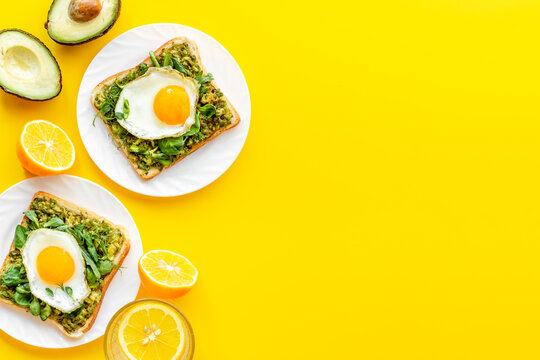 Breakfast with toasts of fried eggs and avocado saurce. Top view