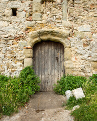 Fototapeta na wymiar Old wooden door in Europe. Limestone house.