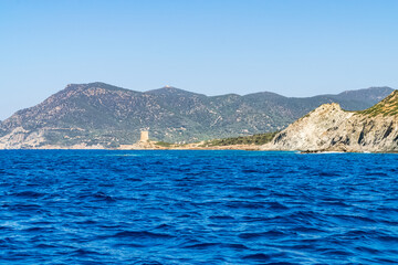 Beautiful view of the southern Sardinian sea from the boat. Note the historic Saracen tower on the...