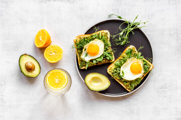 Open sandwich with eggs and avocado on plate. Overhead view