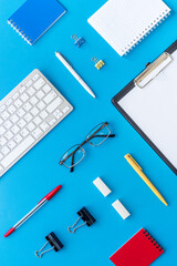 Office desk table with equipment - computer keyboard and notepad, top view