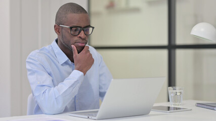 African Man with Laptop Thinking at Work 