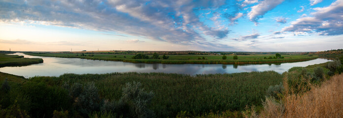 Panorama of the lower Dnieper of the southern region of Ukraine. Evening sunset time. The river in...
