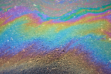 Color gasoline fuel spot on black asphalt, industrial concept. Beautiful rainbow abstract colorful background