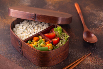 Healthy lunch in wooden japanese bento box.