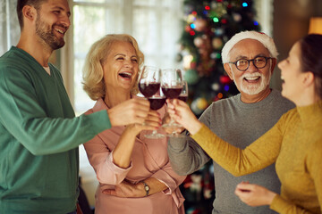 Joyful family toasts with wine while celebrating Christmas at home.