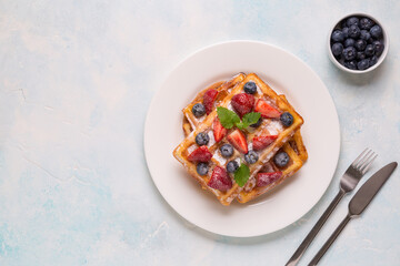 Belgian waffles with strawberries, blueberries and syrup, homemade healthy breakfast
