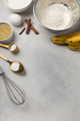 Ingredients for banana bread in bowls on light gray background top view