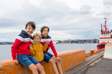 Fototapeta premium Children, standing at the edge of the port in Oslo, Norway, looking at water