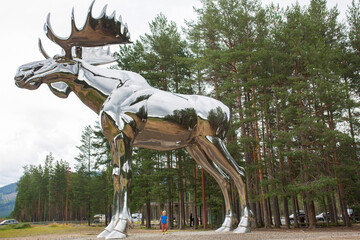 A giant stainless steel moose elk sculpture stands at the side of the road in central Norway