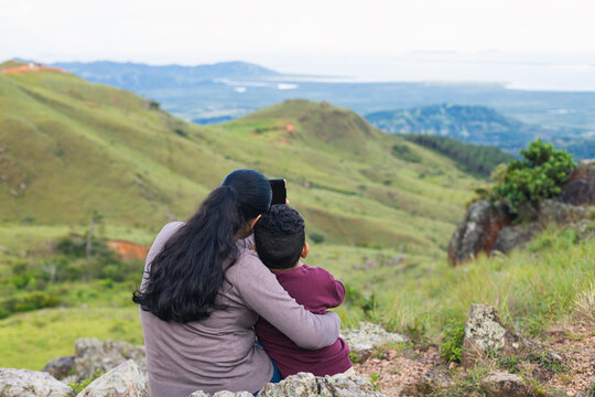 woman taking picture with her son in the mountains