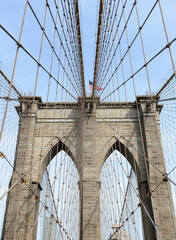 The American flag on the Brooklyn Bridge flies a bright day in the summer