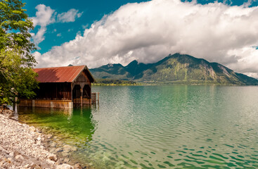 Fototapeta na wymiar Lake in the mountains. Beautiful landscape scenery in upper Bavaria. Reflection Lake Walchensee with Boathouse at a lake. European Alps in Germany, Europe Bavarian Prealps