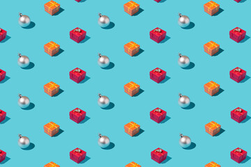 Silver bauble and orange and red christmas box pattern on pastel blue background. Minimal aesthetic concept. New Year's mood.