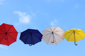 Bunte Regenschirme vor blauem Himmel.