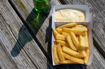 Paper box with french fried potato sticks served outdoor