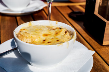 French caramelized onion soup with croutons and gruyere cheesse from oven