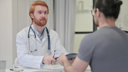 Fototapeta na wymiar Redhead Male Doctor giving Medical Report to Patient 