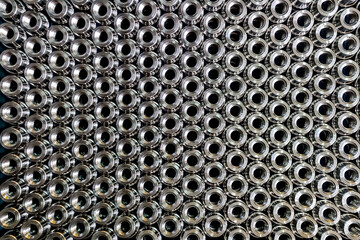 Close up pattern image of stacked stainless steel semi-finished components ready for further...
