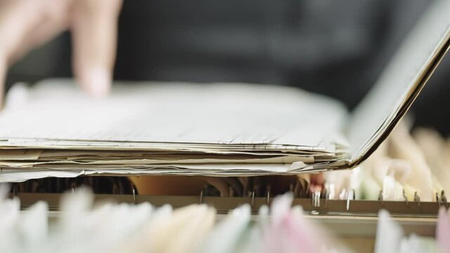 Close-up hand of businesswoman searching for financial and accounting file paperwork in an office file cabinet