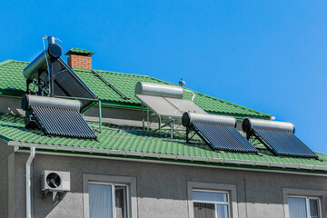 Thermal solar heater panels alternative energy source on the roof of the house against the background of blue sky