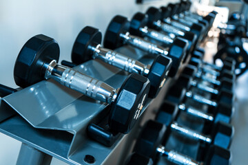 Obraz na płótnie Canvas Rack with dumbbells of different weights close up