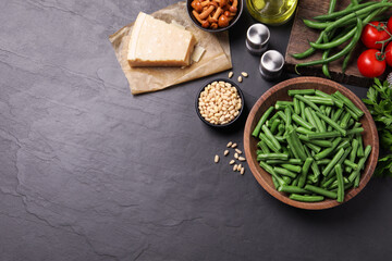 Fresh green beans and other ingredients on black table, flat lay. Space for text