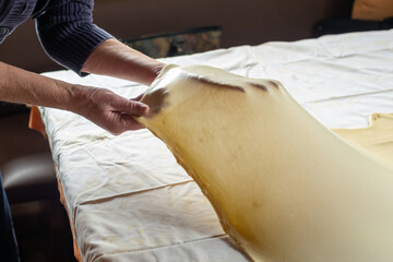 Stretching dough for strudel over a kitchen table